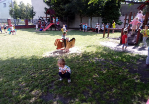 Dzieci bawia sie w ogrodzie przedszkolnym